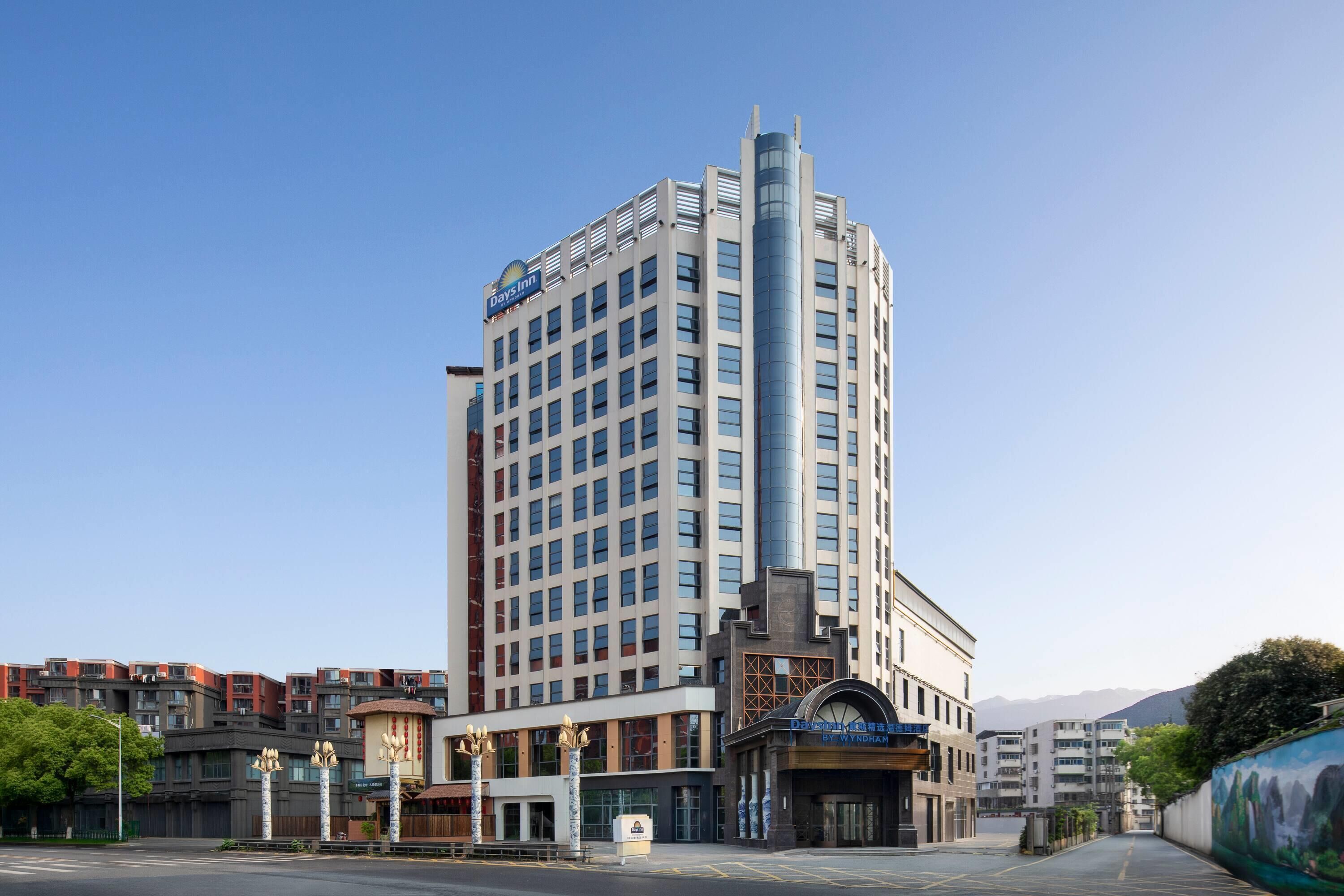 A multi-story hotel with a prominent vertical feature, a large sign, and a distinct entrance with a marquee.