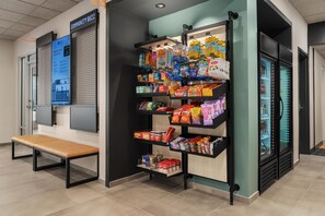 Un petit kiosque où l’on vend divers produits emballés, avec un banc à proximité.