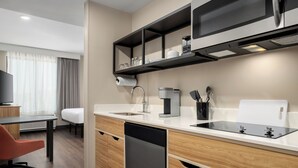 A modern kitchen with a dishwasher, coffee maker, and a microwave. - LivSmart Studios by Hilton Columbia Greystone (Columbia)