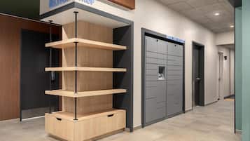 Un interior moderno con una vitrina de madera y una puerta de almacenamiento gris con la etiqueta 'Desbloquea tus tesoros'.