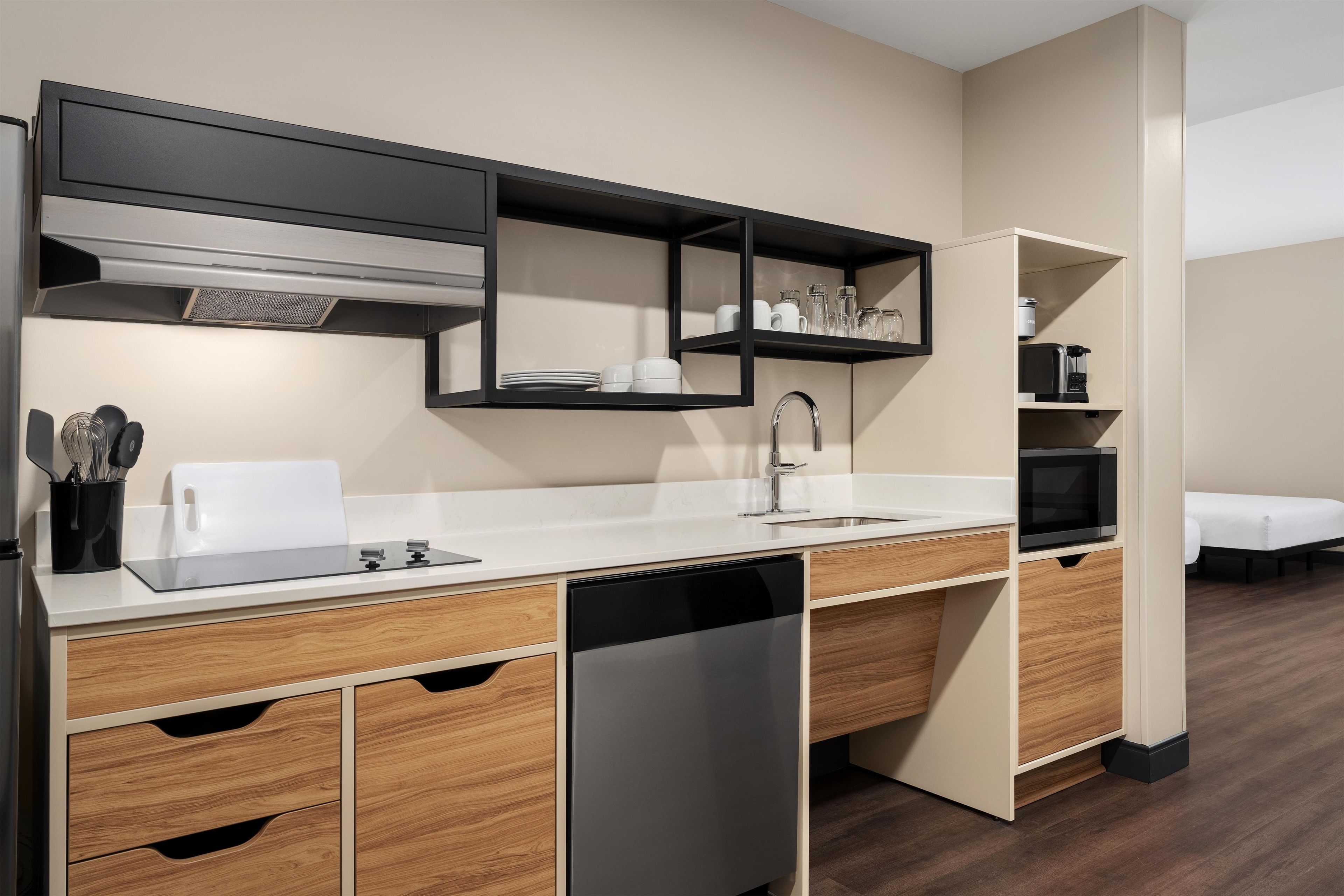 A modern kitchen with a built-in dishwasher, a sink, and a microwave.