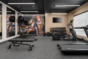 A gym with exercise equipment, a treadmill, and a wall with a colorful mural. - LivSmart Studios by Hilton Columbia Greystone (Columbia)