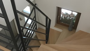 Una escalera con escalones de madera y barandal de metal negro.