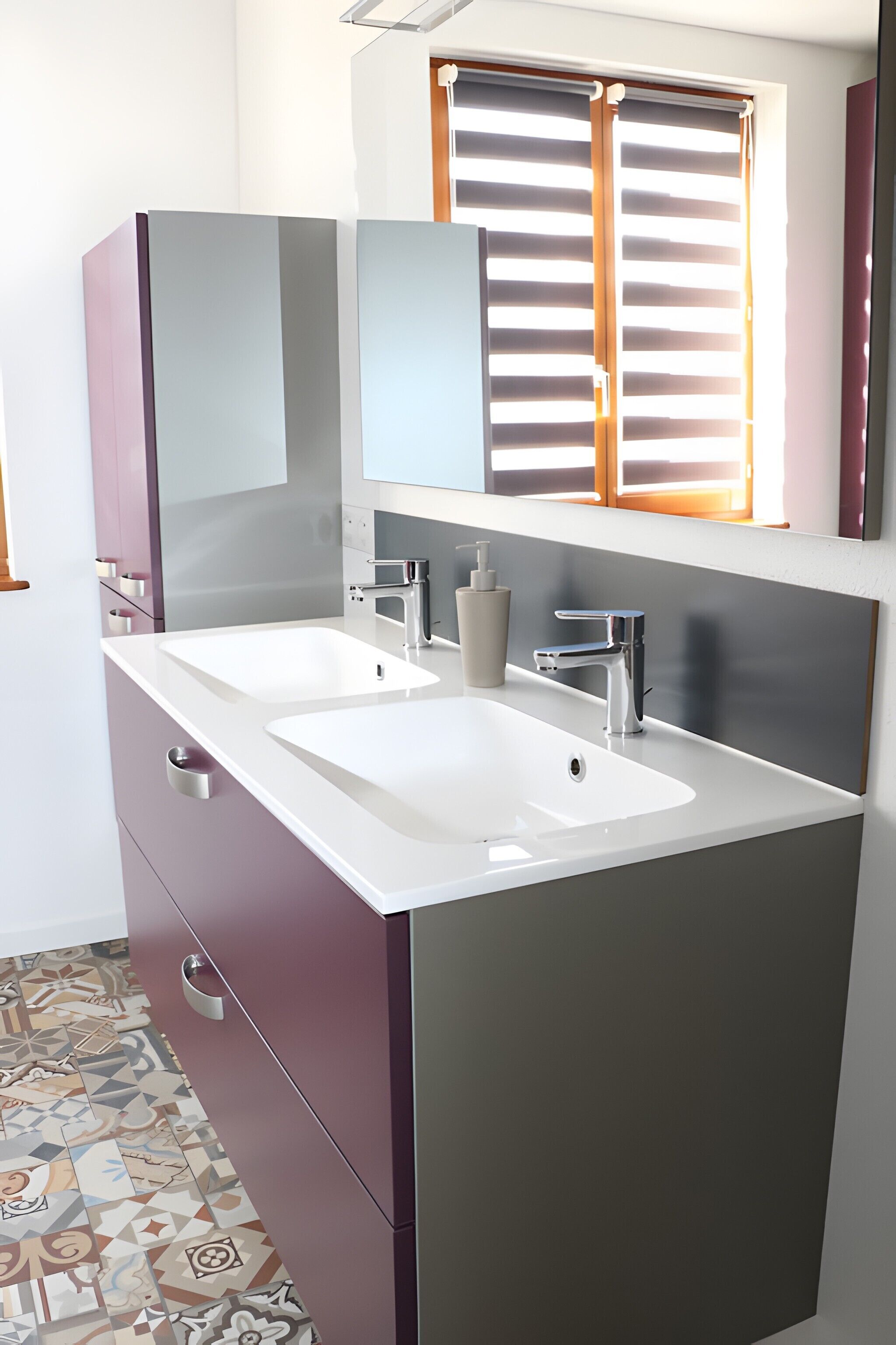 Une salle de bain moderne avec deux lavabos, un miroir et une fenêtre avec des stores.