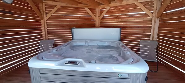 Un sauna en bois, équipé d’un banc, d’un panneau de commande et d’une sortie de vapeur.