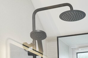 Eine Dusche mit gebogenem Design und runder Duschkopf.