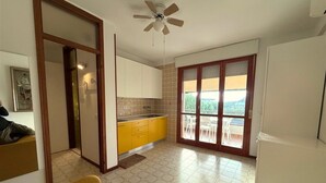 Un espacio habitable compacto con cocina, comedor con vistas y ventilador de techo.