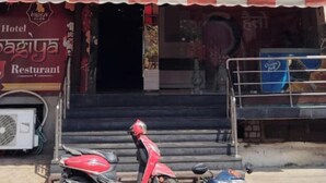 Un edificio de varios pisos con una tienda en la planta baja, un restaurante en el segundo piso y un balcón en el tercero.