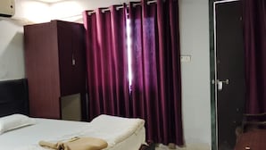 Una habitación de hotel con una cama, un armario y una puerta.