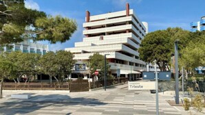 En byggnad med flera våningar, där ett skylt anger att det är ”Isola Strada” och ”Tungomare Trieste”.