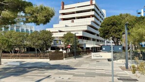 A multi-story building with a sign indicating 'Isola Strada' and 'Tungomare Trieste.' - Inviting apartment near the beach (Lignano Sabbiadoro)