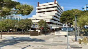 Un immeuble à plusieurs étages, sur lequel on peut lire une enseigne indiquant « Isola Strada » et « Tungomare Trieste ».