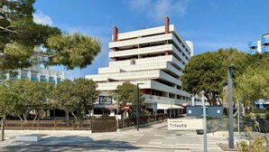 En bygning med flere etager, hvor der står 'Isola Strada' og 'Tungomare Trieste'.