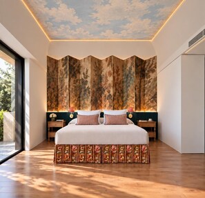 Un dormitorio con una cama grande, un mural en el techo y vistas al exterior.