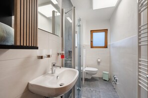 Ein modernes Badezimmer mit Duschkabine, Waschbecken und Toilette.