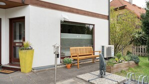 A residential building with a wooden bench, a potted plant, and a security camera. - Apartment “Linie 8” with Wi-Fi (Dresden)
