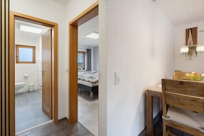 A hallway with a wooden door leading to a bathroom and a bedroom. - Apartment “Linie 8” with Wi-Fi (Dresden)