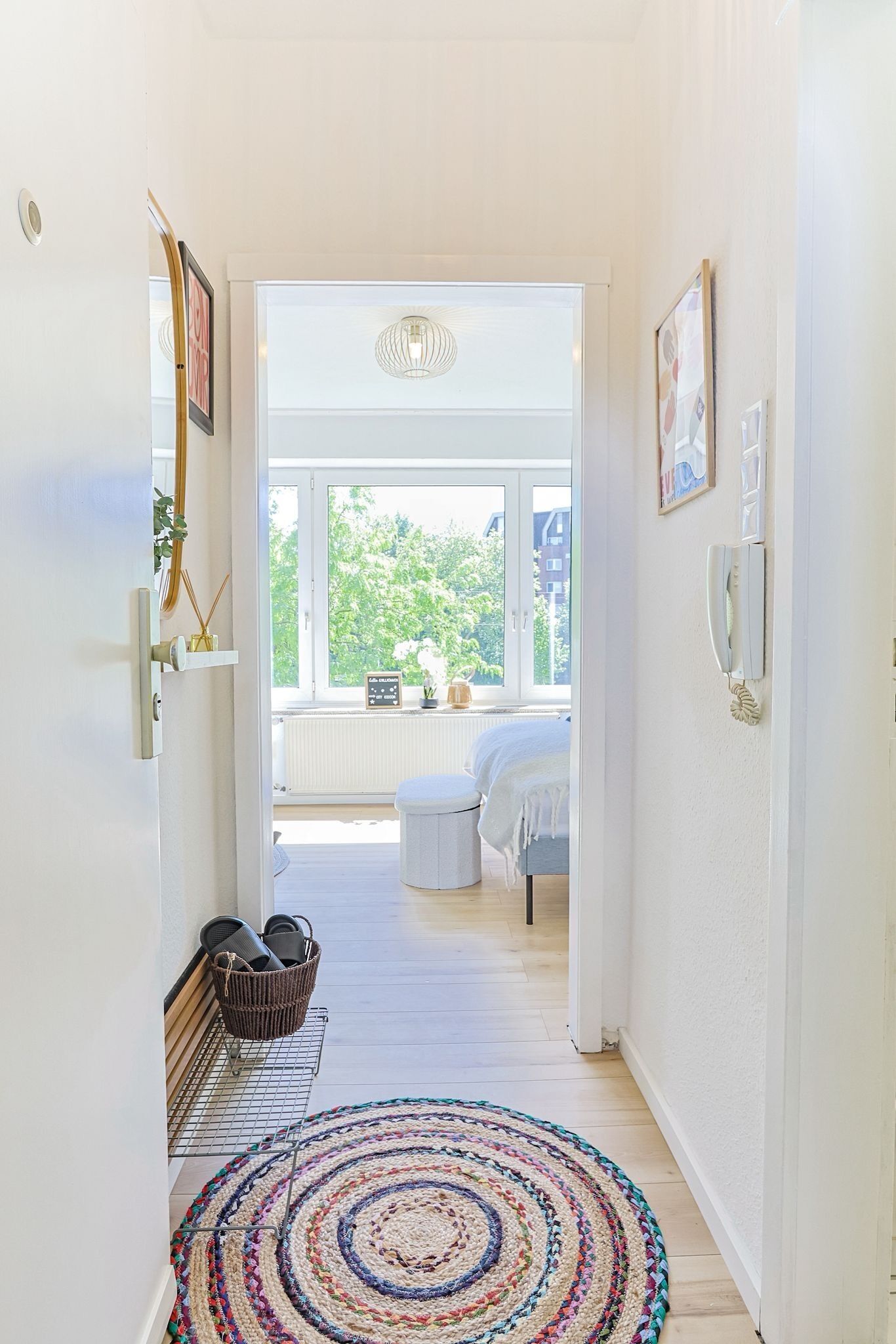 Ein Flur mit Blick auf ein Schlafzimmer, einem Heizkörper, einem Fenster und einer Tür.