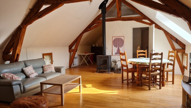 Ein Loft-Zimmer mit einer Couch, einem Holzesstisch und Stühlen.