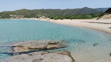 Sulla spiaggia, sabbia bianca, lettini da mare, ombrelloni