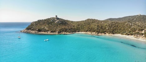 On the beach, white sand, sun-loungers, beach umbrellas