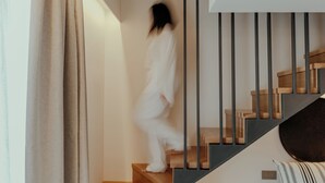 Eine Treppe mit Holzboden und einem schwarzen Geländer.
