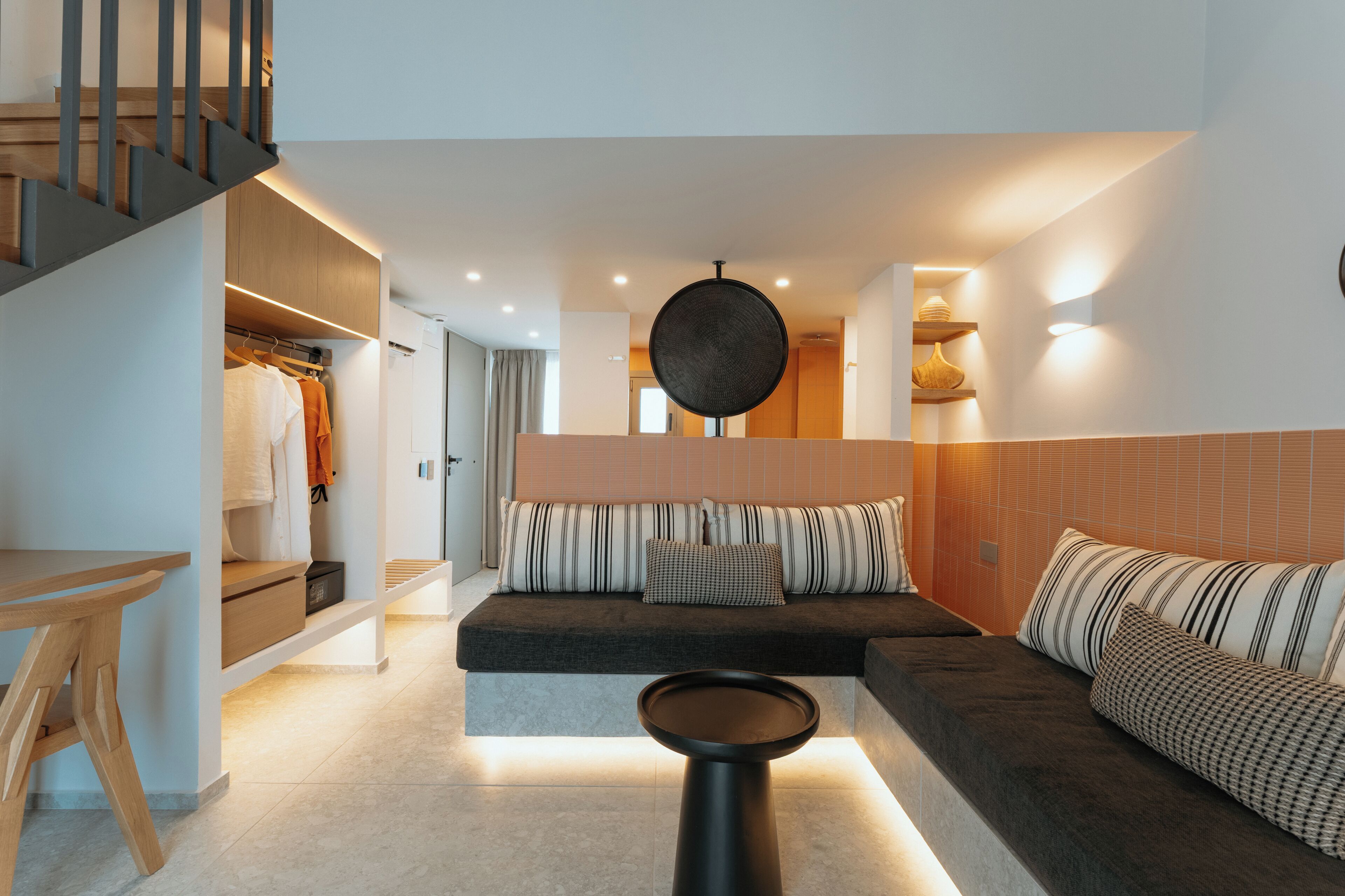 Ein modernes Interieur mit einer Couch, einem runden Tisch und einer Treppe.
