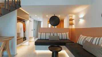 Ein modernes Interieur mit einer Couch, einem runden Tisch und einer Treppe.