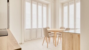 A modern dining area with a round table, six chairs, and a wooden partition. - Hostmate - Milano - Viale Corsica (Milano)