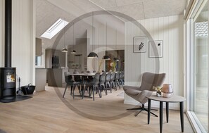 A modern interior with a dining area, a fireplace, and a large window. - Amazing home in Bogense with sauna (Bogense)