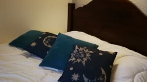 A bed with white bedding and three decorative pillows with celestial designs. - Studio near the Dordogne river, close to all amenities. Pastoral setting, (Argentat-sur-Dordogne)