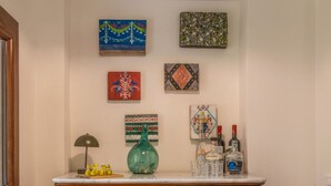 A wooden dresser with drawers, a green vase, and decorative bottles on top. - Sky Room - Casa Silva (Lorica)