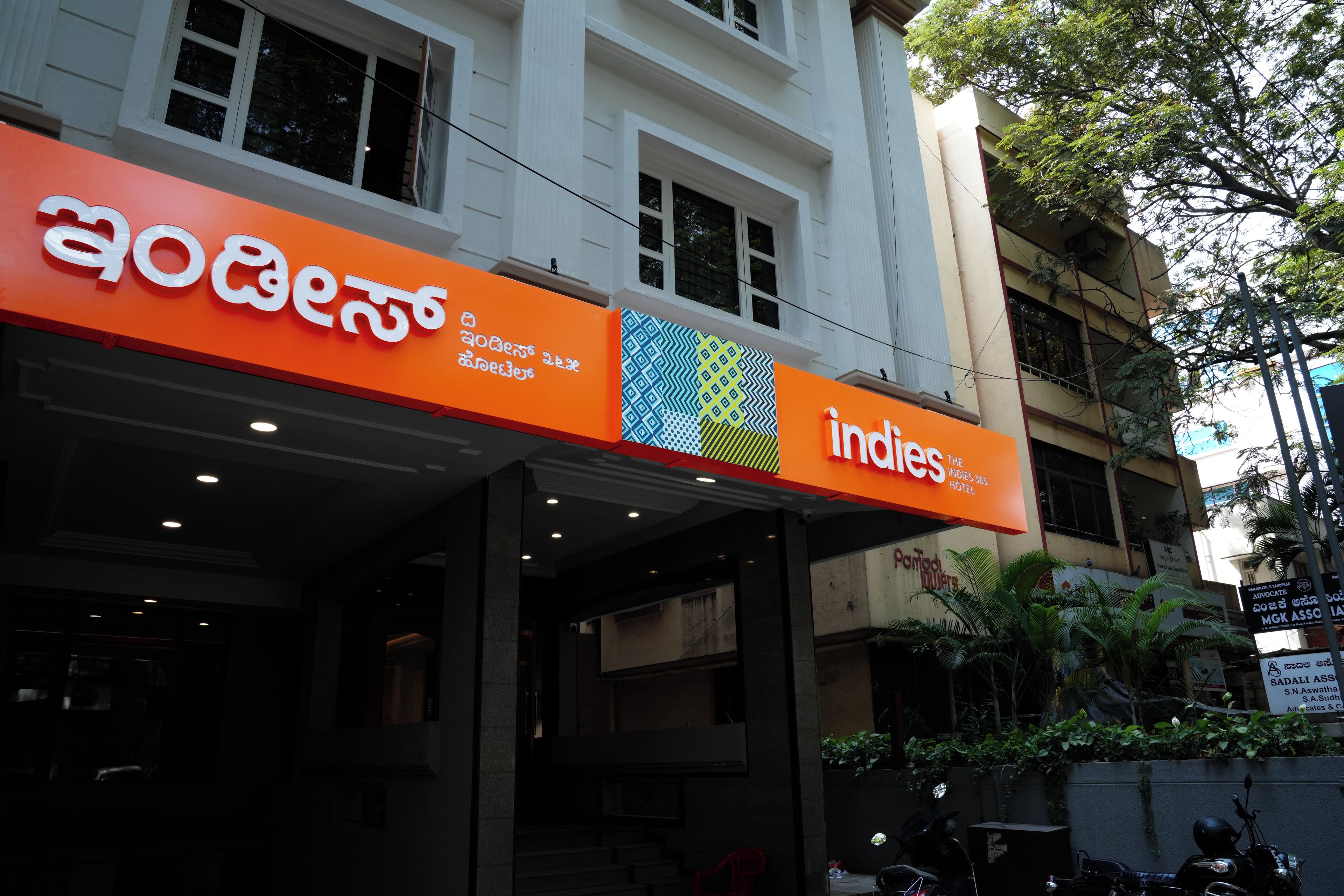 A hotel with a prominent signboard displaying the name 'Indies Hotel' and a logo.