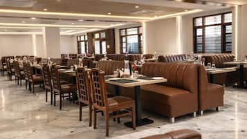 Un restaurante espacioso con varias zonas de estar, incluyendo cabinas y mesas, y un suelo de mármol pulido.