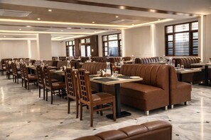 Un restaurante espacioso con varias zonas de estar, incluyendo cabinas y mesas, y un suelo de mármol pulido.