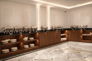 Una cocina moderna con electrodomésticos integrados, armarios de madera y suelo de mármol.