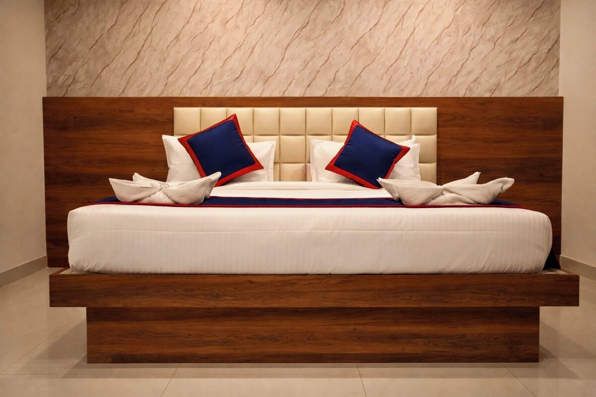 Una cama moderna con cabecera de madera, ropa de cama blanca y almohadones decorativos.