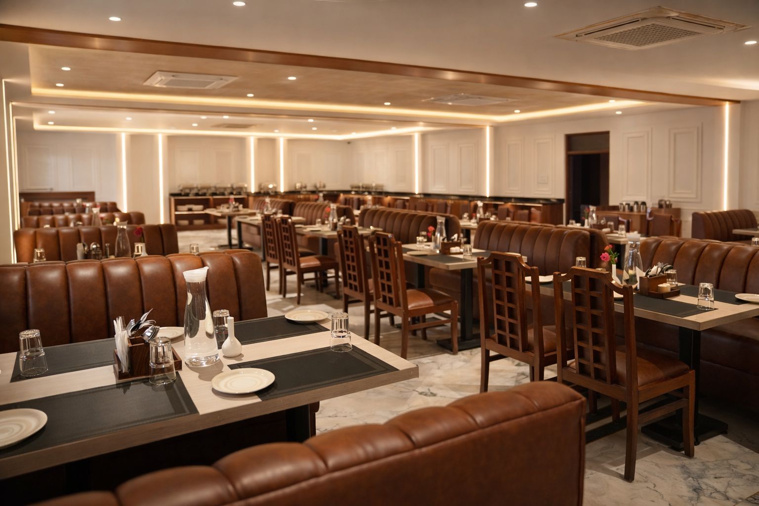Un restaurant spacieux doté de plusieurs espaces de restauration, notamment des banquettes et des tables, et d’un décor intérieur propre et moderne.