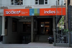 Entrada de un hotel con un letrero que dice 'Indies Hotel' y una escalera que lleva a la entrada.