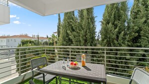 A balcony with a table, chairs, and a bottle of Fanta. - Cosy 2Br Family Apartment - Mythical Sands Resort (Paralimni)