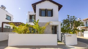 A modern two-story house with a balcony, a garage, and a well-maintained garden. - Stylish Villa | Private Pool - Garden - Near Beach (Paralimni)
