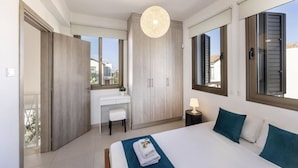 A bedroom with a bed, a desk, and a wardrobe. - Stylish Villa | Private Pool - Garden - Near Beach (Paralimni)