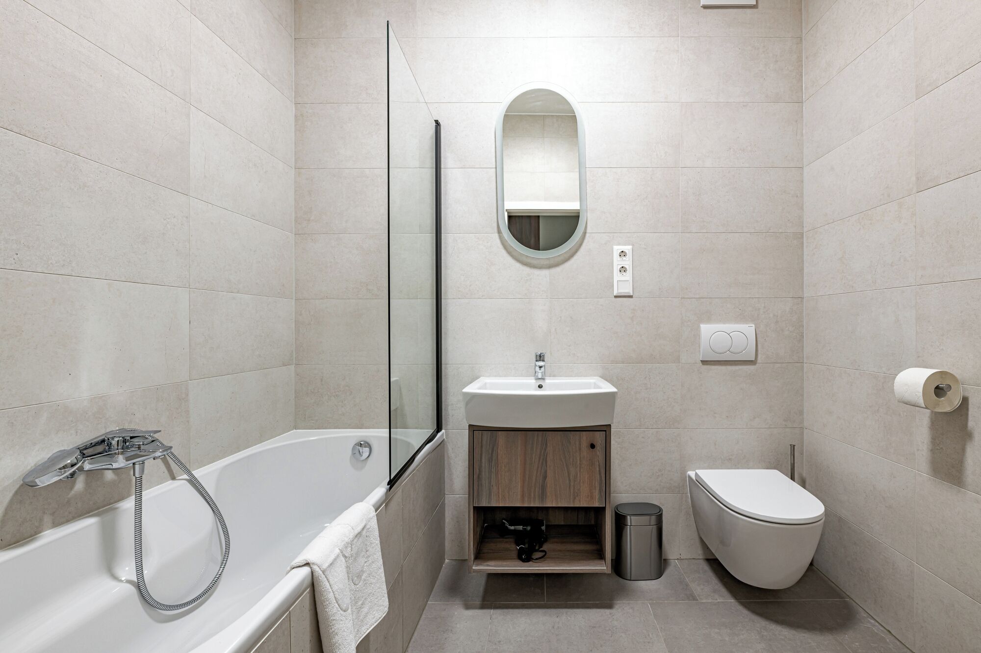 A modern bathroom with a bathtub, sink, and toilet.