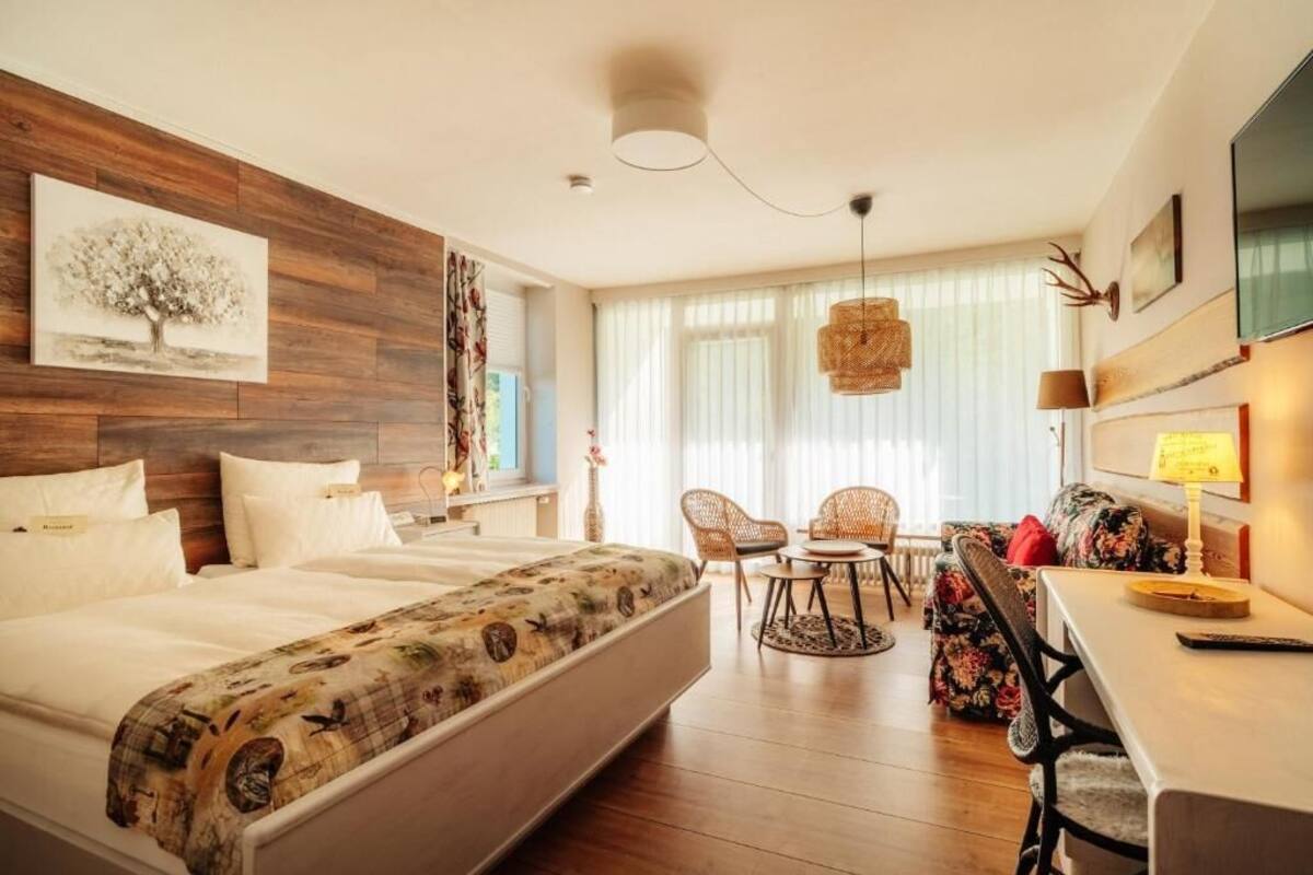Une chambre d’hôtel équipée d’un lit, d’un bureau, d’une chaise, d’une télévision et d’une fenêtre avec des rideaux.