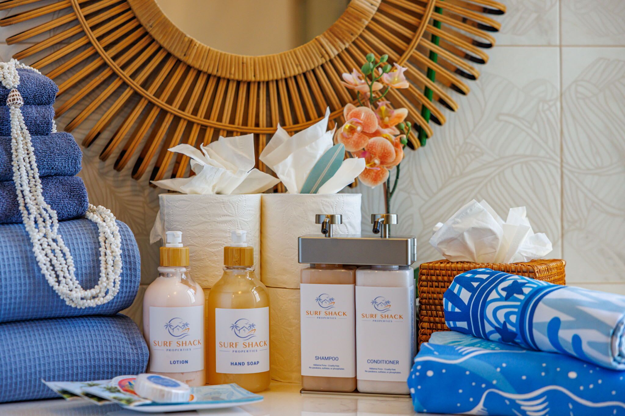 A bathroom vanity with toiletries including lotion, hand soap, shampoo, and conditioner.
