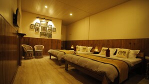A hotel room with two beds, wooden flooring, a wall-mounted TV, and framed pictures. - Latitudee Boutique Rooms (Darjeeling)