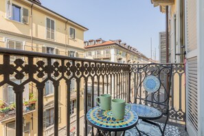 A balcony with a wrought iron railing, a small table with a mosaic top, and two green cups. - Casa Tropicana RO-JO by Wonderful Italy (Torino)