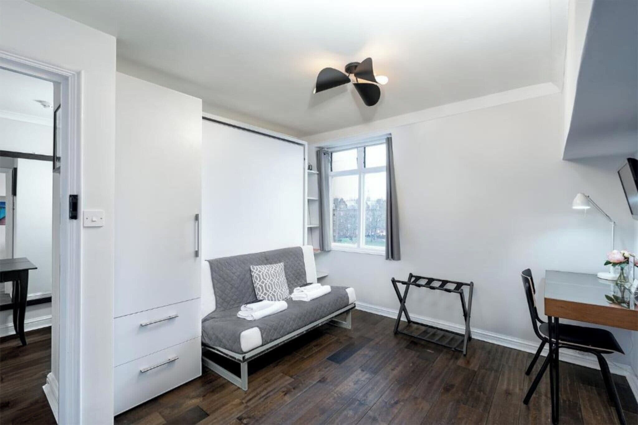 A compact room with a bed, a desk, and a chair.