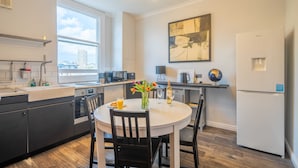 Una cocina moderna con comedor, un amplio ventanal y un globo terráqueo sobre la mesa.