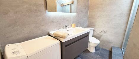 Regadera, secadora de cabello, toallas, papel de baño